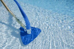 Pool maintenance in summer with clean swimming pool water and clear surface