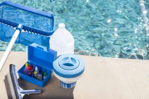Testing swimming pool water using test strips to check chlorine and pH levels