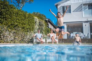 Family swimming safely in clean pool water with proper swimming pool maintenance